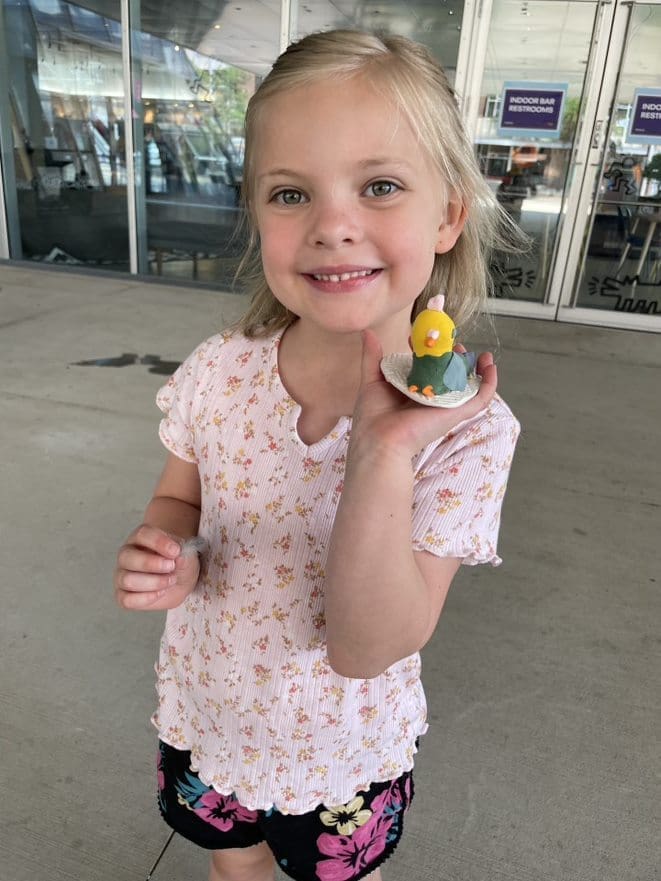 A girl holding a sculpture she made.