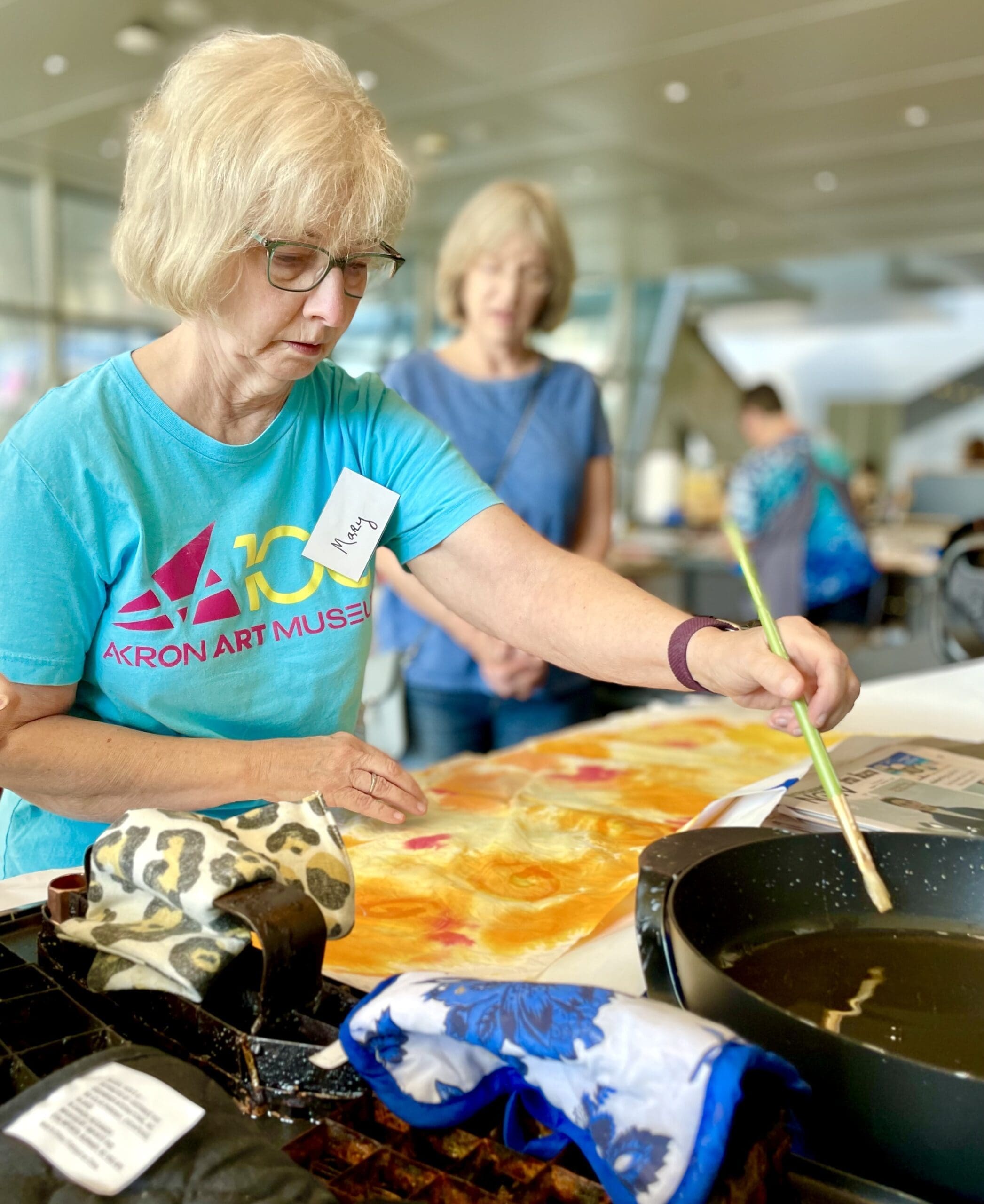 An over 50 person working on creating a piece of artwork.