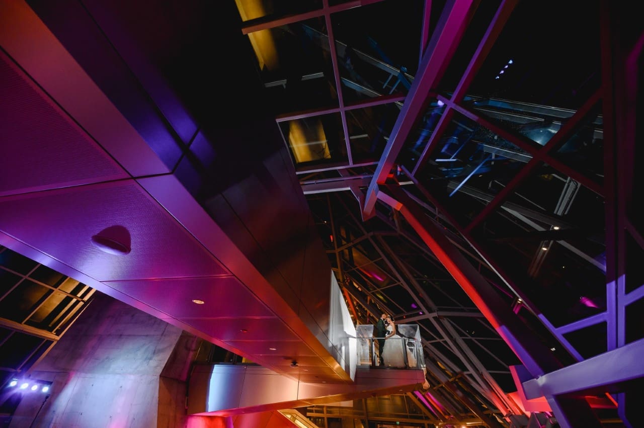 Event Rental Space, the Akron Art Museum main lobby at night, lit with colored lights.