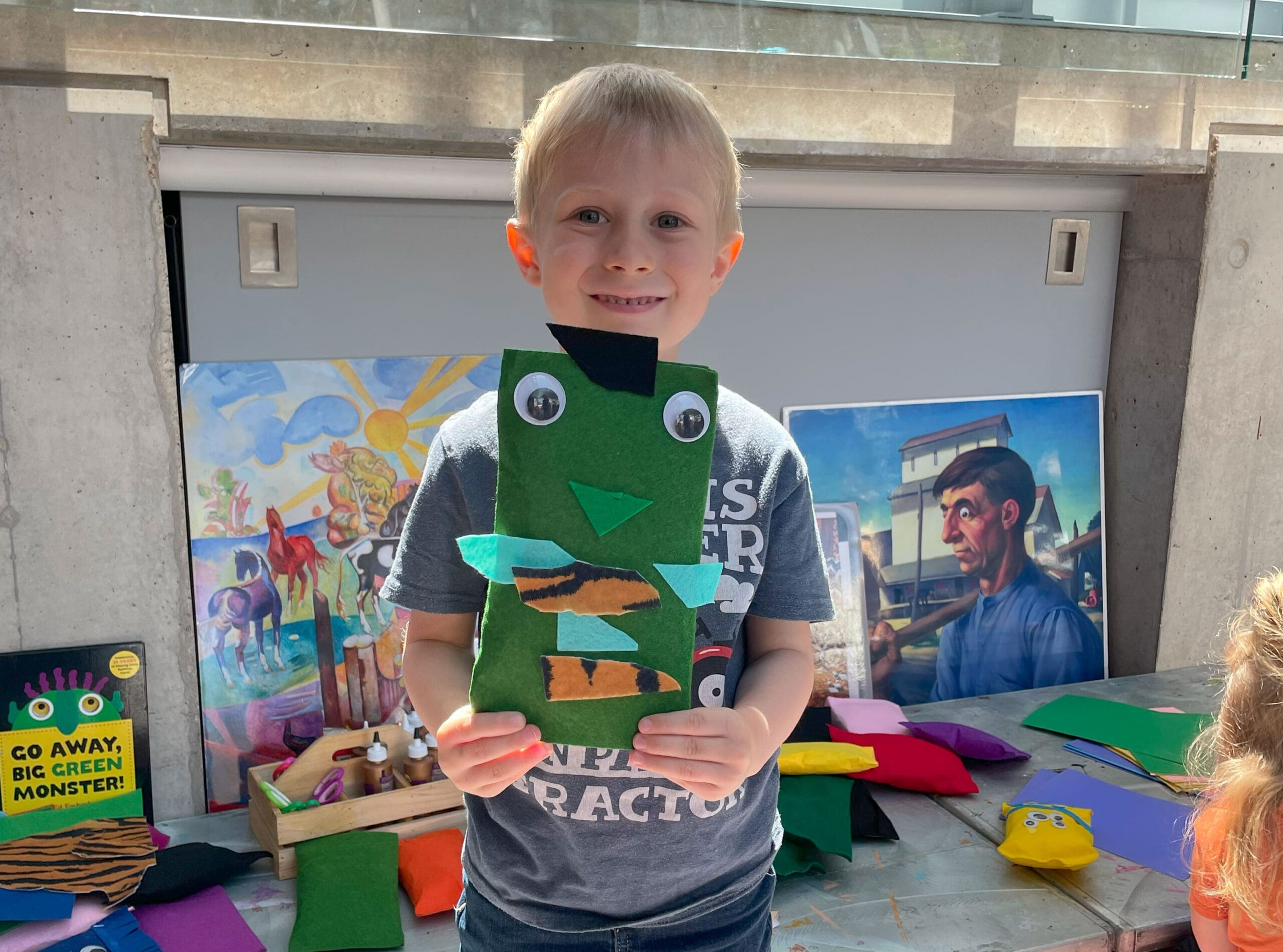 A little boy holding a stuffie toy he just made.