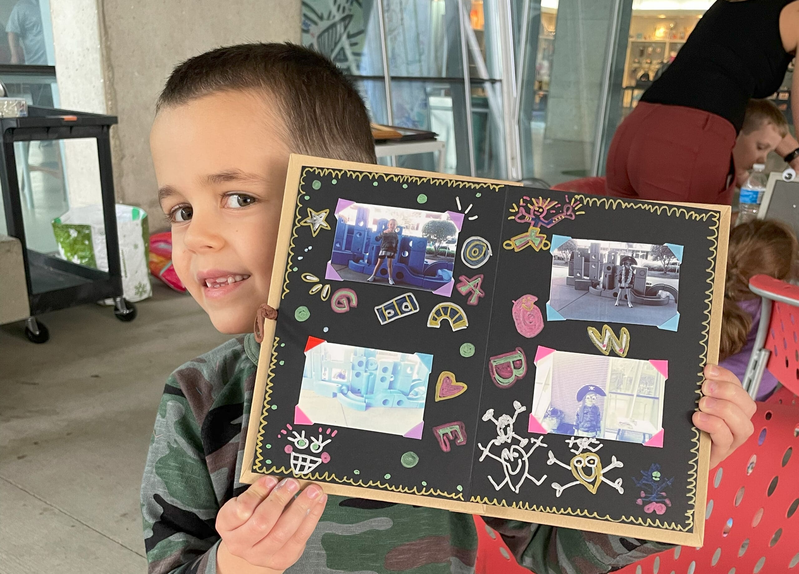 A small child showing a handmade book he made.