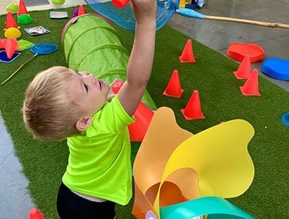A child playing with plastic flowers.