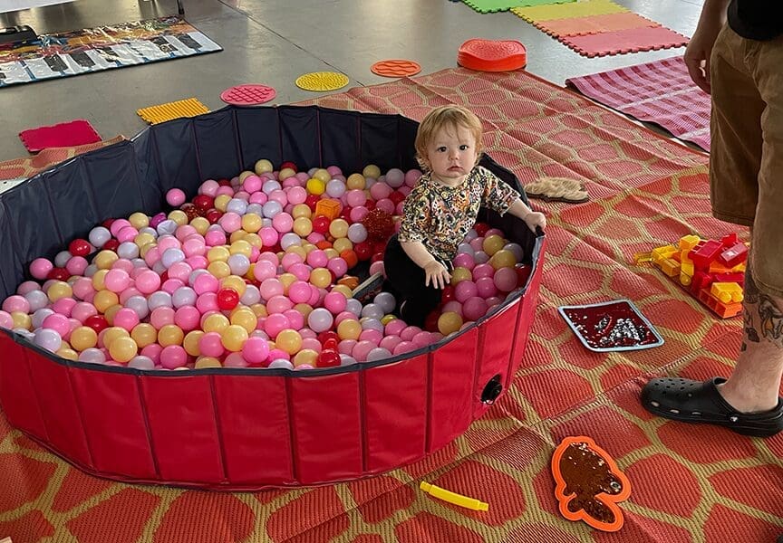 A bably playing at a Mess Makers event at the Akron Art Museum
